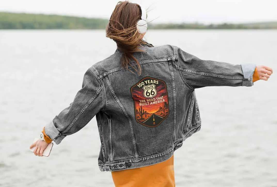 A denim jacket with the centennial sunset artwork across the back